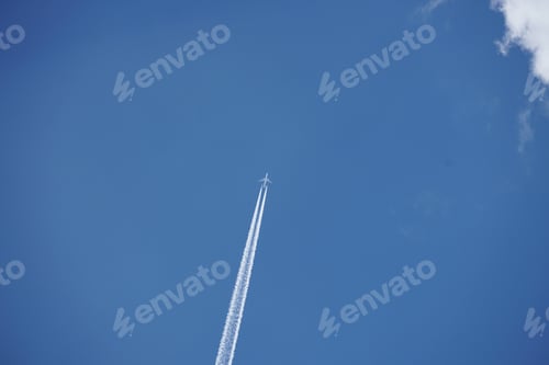 Preview: Horizontal shot of a plane leaving tracks in the blue sky