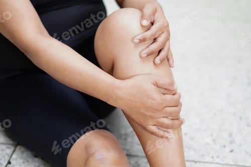 Preview: Asian middle-aged lady woman patient touch and feel pain her knee and leg