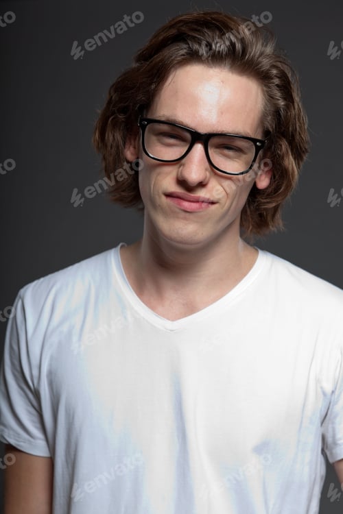 Preview: Handsome Young Man With Brown Long Hair And Retro Glasses Isolated On Grey Background. Fashion