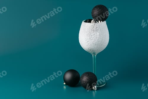 Preview: Decorative snow-covered frosted wine glass on green background