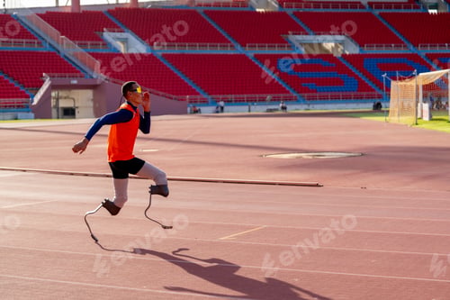 Preview: Asian para-athletes with prosthetic blades sprint on a running track at stadium.