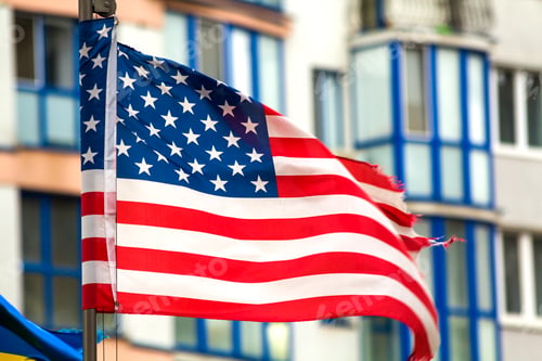 Preview: Close up of the us flag against city skyline