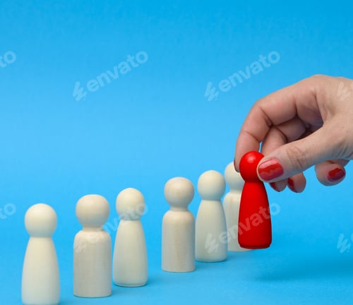 Preview: Female hand holds a wooden red figurine chosen from the crowd