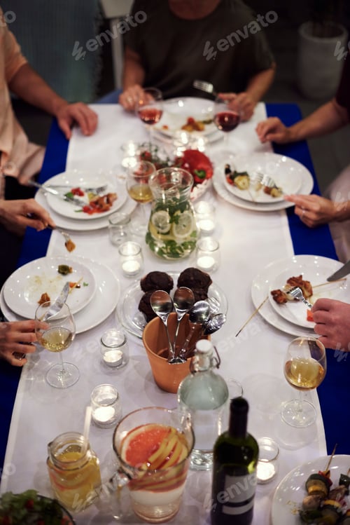 Preview: Group of people sitting at table, enjoying meal, low section