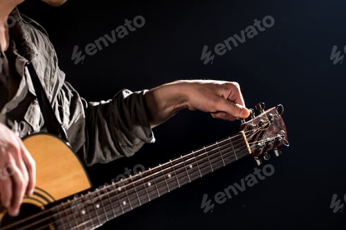 Preview: Guitarist, music. A young man plays an acoustic guitar on a black isolated background