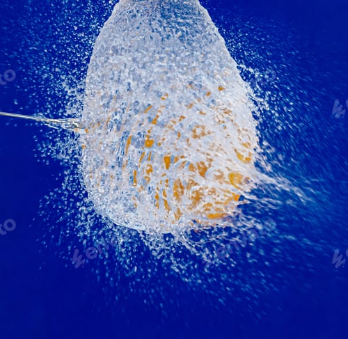 Preview: Closeup shot of a water balloon splash with a blue background