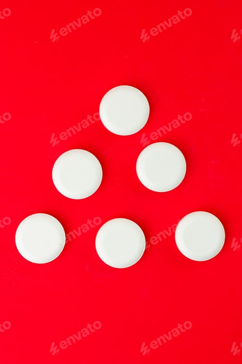 Preview: Vertical shot of white pills on the red background