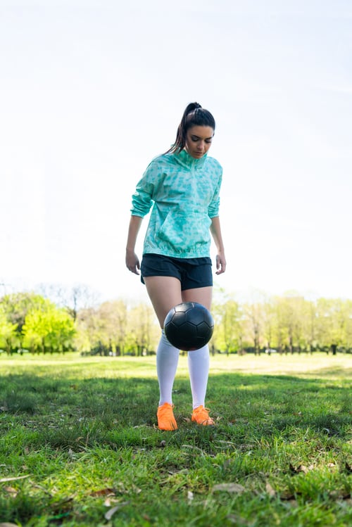 Preview: Young woman practicing soccer skills with ball.