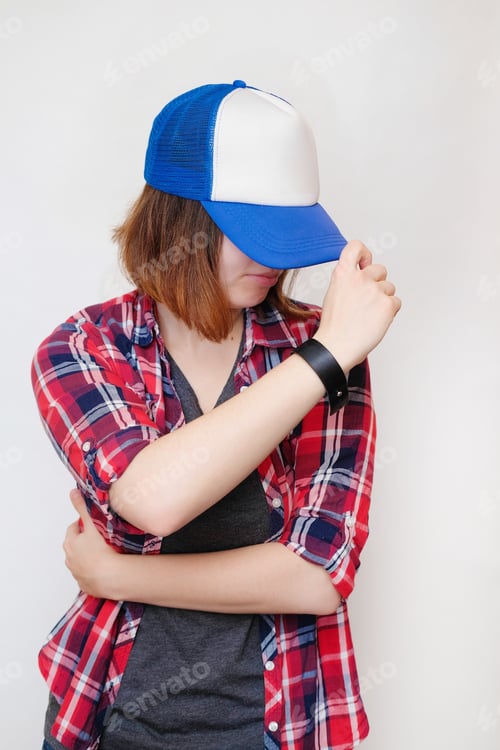 Preview: Hipster In A Plaid Shirt And A Cap. Young Woman On White Background.