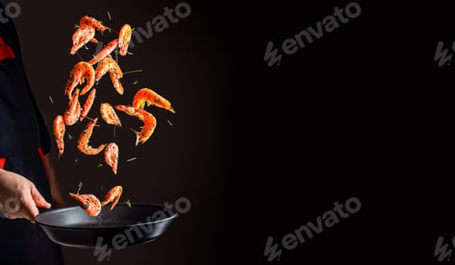 Preview: cooking shrimp in pan. Chef cooking prawn on a dark background. copy space for text
