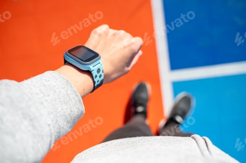 Preview: Hand with smartwatch monitoring activity on sports stadium