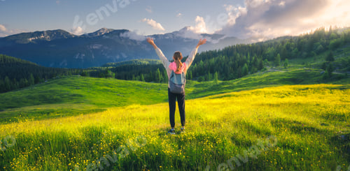 Preview: Happy girl on the hill with yellow flowers and green grass