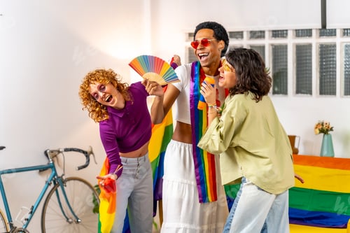 Preview: Friends celebrating pride with rainbow hand fan and flags