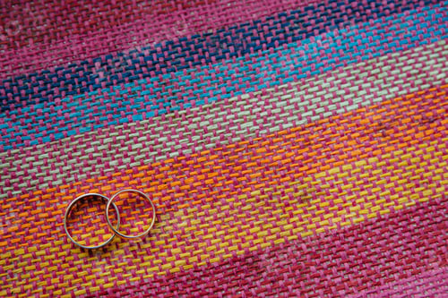 Preview: golden wedding rings on colourful tissue with blank space for your promotional content