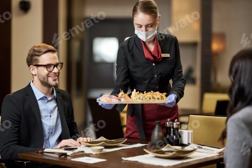 Preview: Pleased gentleman and his date being served sushi at restaurant