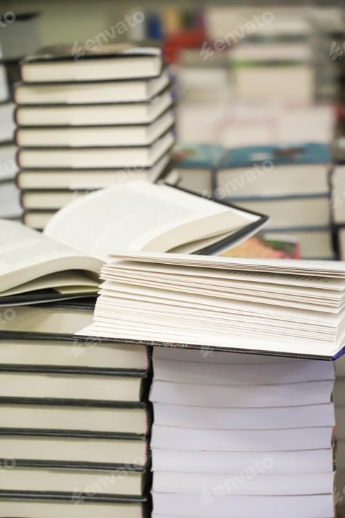 Preview: stack of books on the table. open book