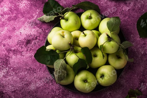 Preview: Fresh ripe green apple in purple background.