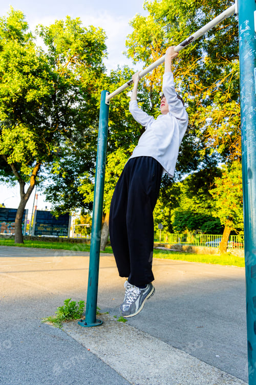 Preview: Young Man Doing Pull-Ups on a Sunny Afternoon in a Park