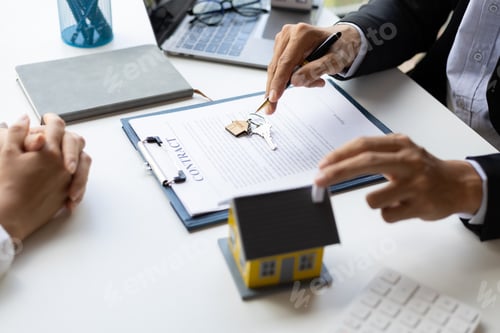 Preview: Real estate agent discussing the terms of the house purchase agreement contract document.