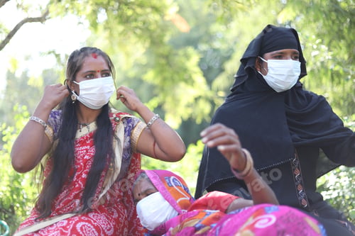 Preview: Closeup shot of three Indian women with traditional dresses and white masks