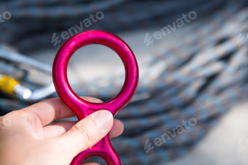 Vista previa: Cuerda de escalada enrollada y mosquetón de acero. Material de alpinismo: carabina