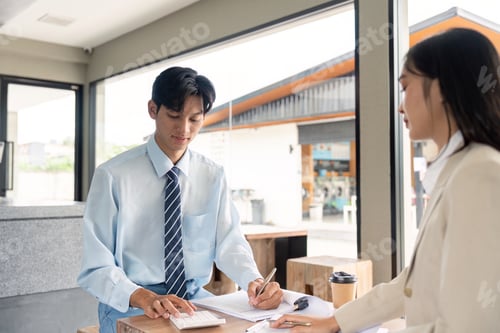 Preview: Finance Specialist Reviewing Reports and Using Calculator in Cafe Setting