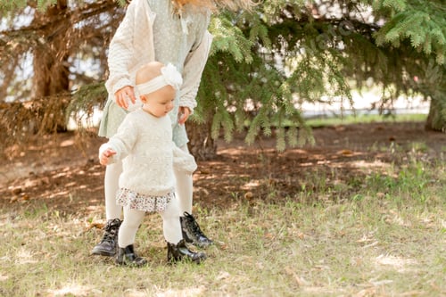 Preview: little girl learns to walk. The child takes the first steps on the street.