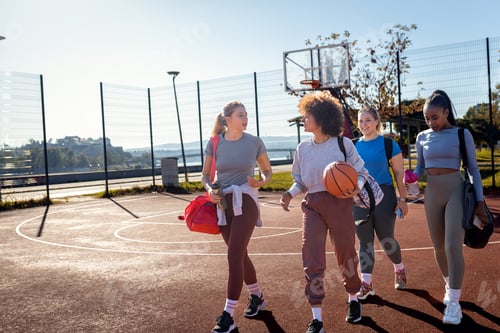 Preview: Diverse group of young woman walking on basketball court preparing to play.