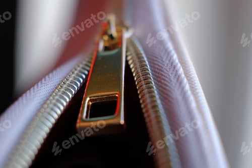 Preview: Selective focus, yellow metal zipper of a makeup bag or small purse macro pattern background