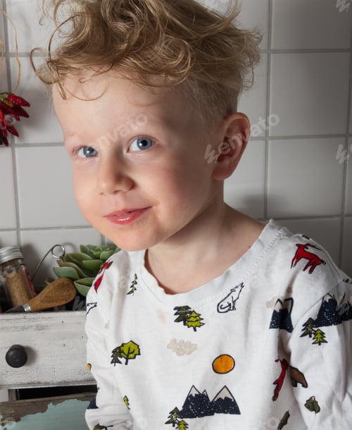 Preview: Portrait of a blue-eyed little boy who smiles shyly