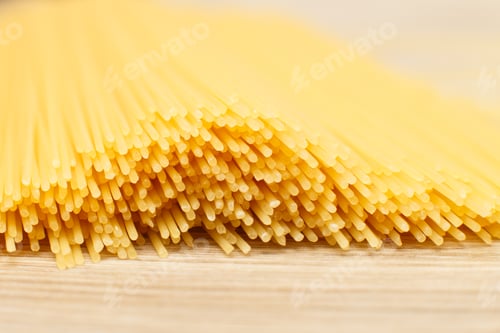 Preview: spaghetti yellow background close. raw pasta macro.