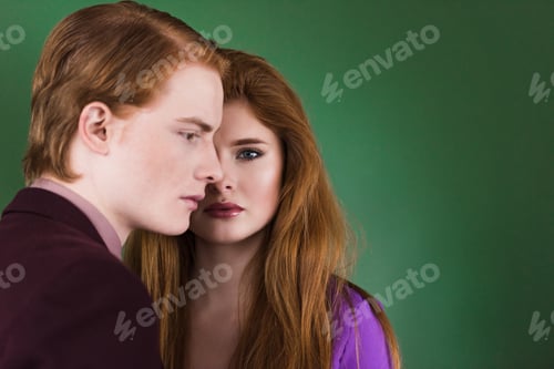 Preview: Side view of young male model with girlfriend near isolated on green