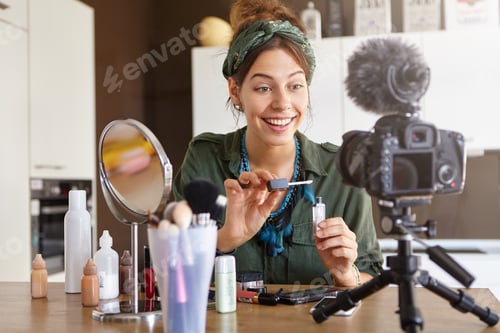 Preview: Female video channel host using lip gloss for putting make up, telling about cosmetics to her custom