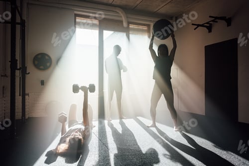 Preview: Unrecognizable women exercising with dumbbells and ball in gym