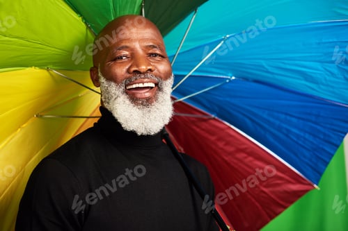 Preview: Keep yourself covered. Shot of a senior man posing with a colorful umbrella over his head.