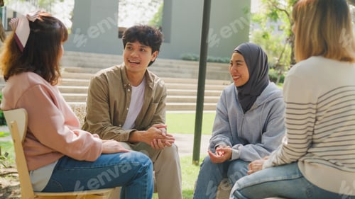 Preview: Small Asian group of people sit in a close circle and talk to a therapist in park