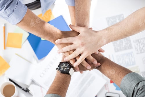 Preview: Close-up partial view of businessmen stacking hands while working on project together, business