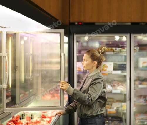 Preview: Woman Choosing Frozen Food From A Supermarket Freezer