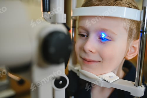 Preview: Boy undergoing vision diagnostics with modern equipment at ophthalmology clinic