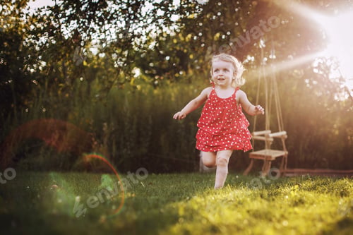 Preview: happy baby smiling. little girl running at sunset