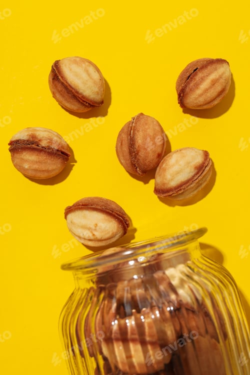 Preview: Nuts cookies in a glass jar on a yellow background