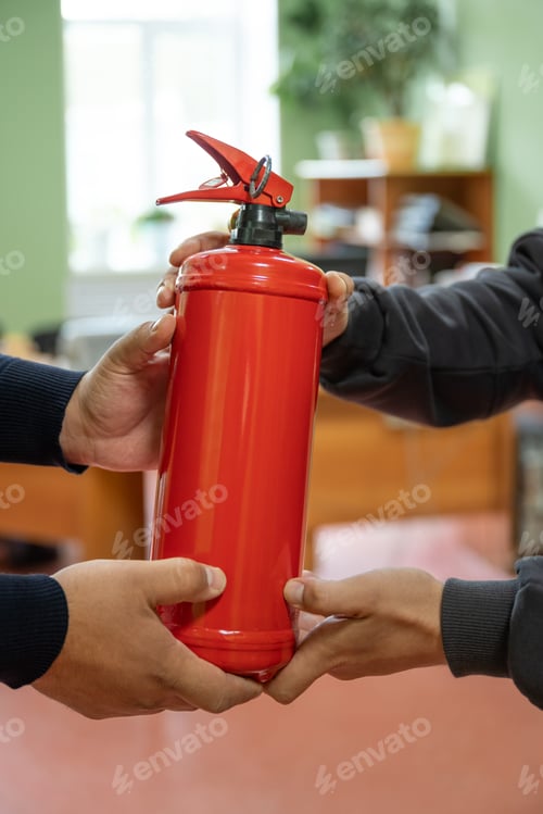 Preview: Employees are holding a fire extinguisher in the office.