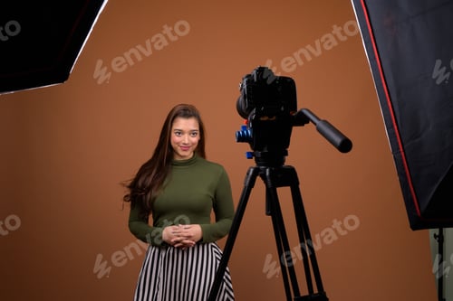 Preview: Young beautiful Indian woman vlogging against brown background