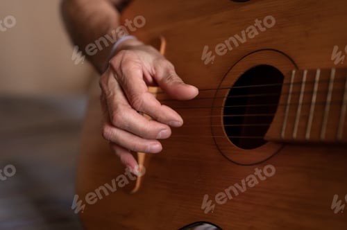 Preview: male hands elderly senior man holding playing classical guitar at home. guitarist play amateur music