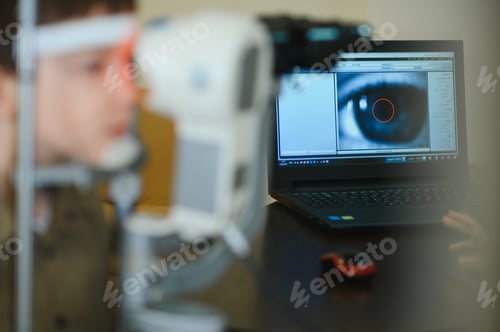 Preview: Ophthalmologist examining child's vision with modern equipment in clinic