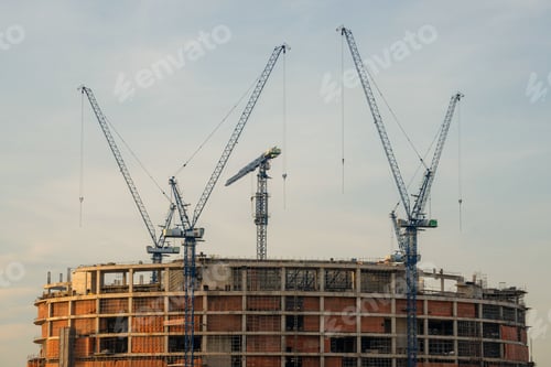 Preview: Crane and a building under construction against a blue sky background.