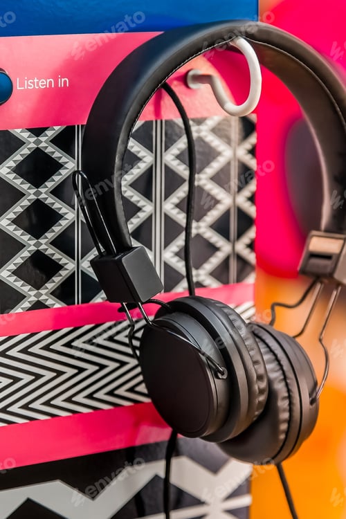 Preview: Vertical shot of black headphones hanging on a decorative background