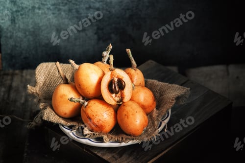 Preview: Fresh loquat served in plate over rustic wooden table