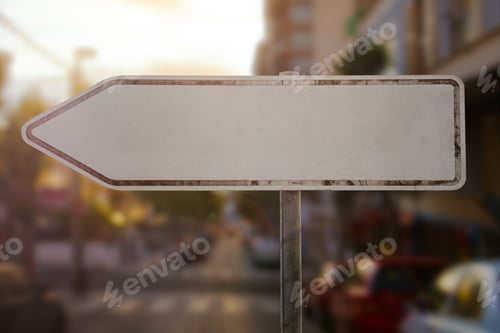 Preview: Closeup of a blank direction sign with an arrow to the left in a city at sundown