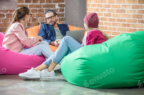 Preview: Young people sitting in bean bag chairs and chatting